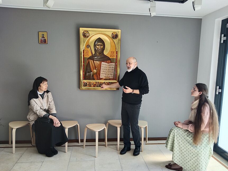 Ikonenschreiber Vater Razvan Gasca erklärt in seinem Atelier die Ikone des Hl. Benedikt