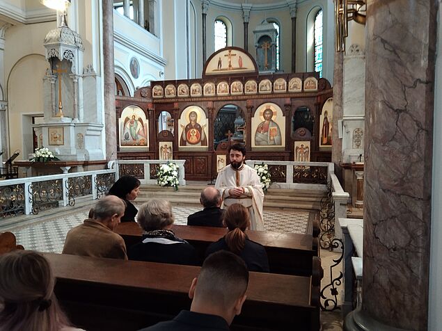 Der rumänisch-orthodoxe Priester Ioan Moga spricht mit Studierenden in seiner Pfarrkirche St. Antonius