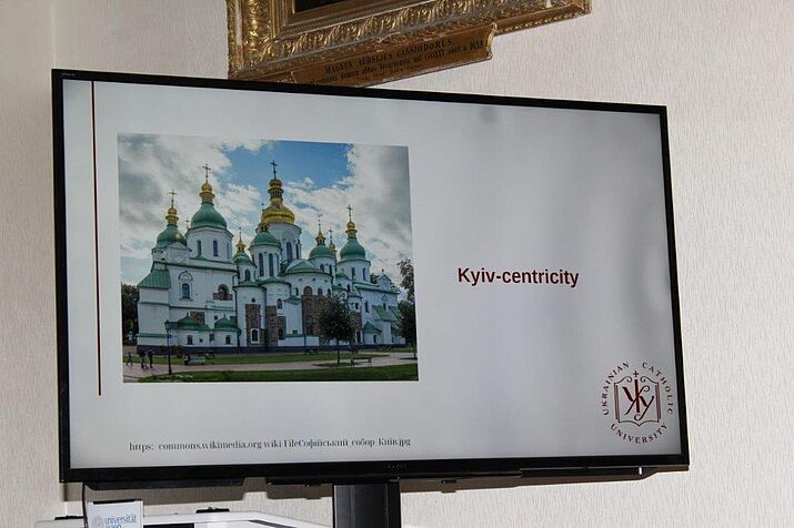 Bildschirmansicht von der Einleitung durch Ivan Almes, links ein Foto einer orthodoxen Kirche in Kiev, rechts Text: Kyiv-centricity, rechts unten Logo der ukrainian catholic university