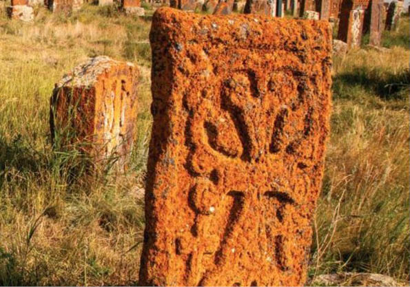 Christlicher Grabstein, orangeroter Stein mit eingemeißeltem Kreuz